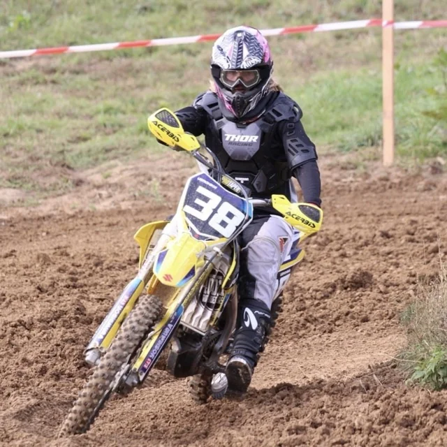 Veronika, remote graphic designer and social media specialist at Platinum Wheels and Tires, racing motocross on a yellow Suzuki dirt bike